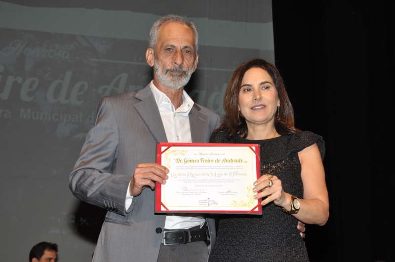 Geraldo Sales de Souza entrega a comenda a sua homenageada.