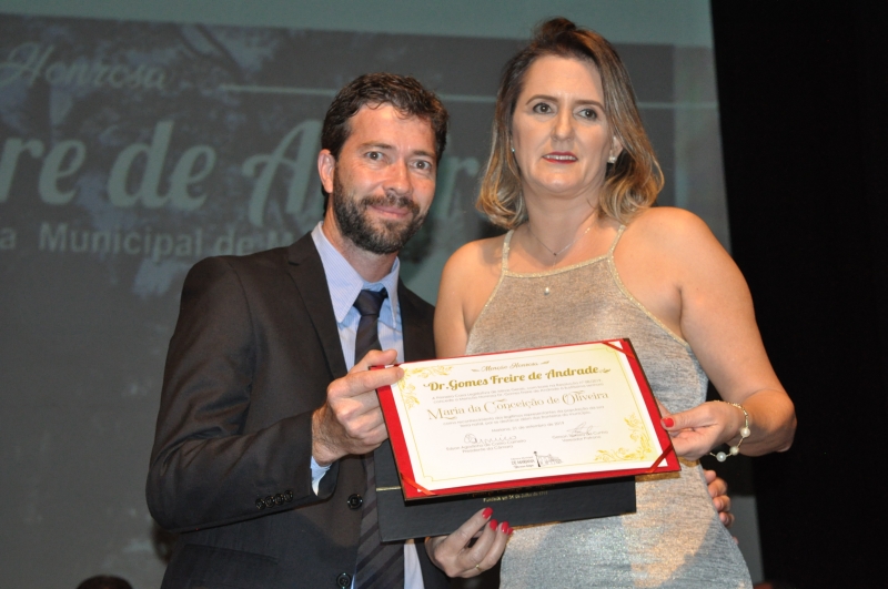 Gerson Cunha entrega a comenda a sua homenageada.